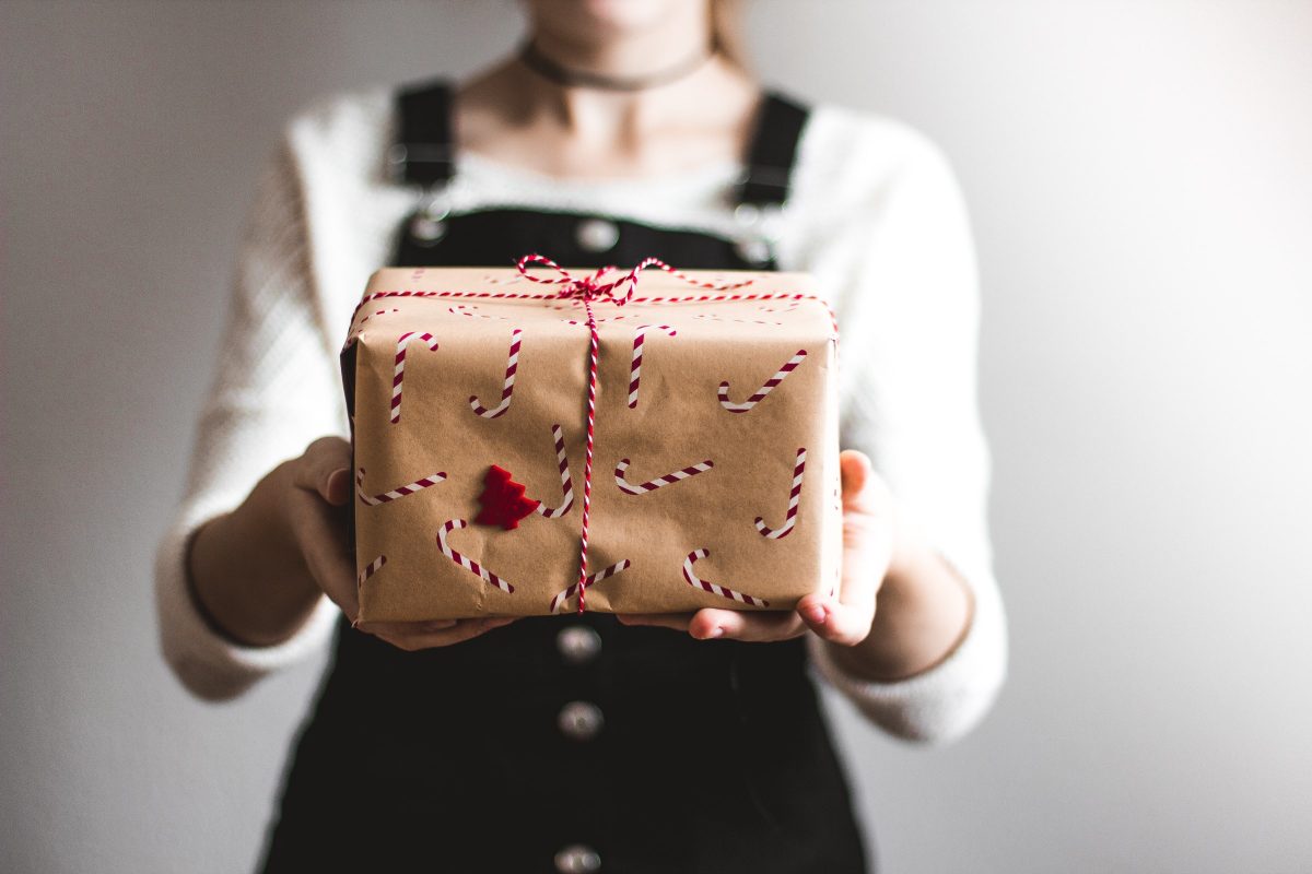 Image of woman holding out a gift-wrapped box