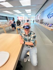 Zac sits in the Apple store wearing an Apple Vision Pro 