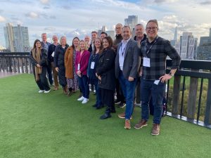 The first cohort of 'transforming together' universities on the roof of Adobe's London offices with a view of London. 