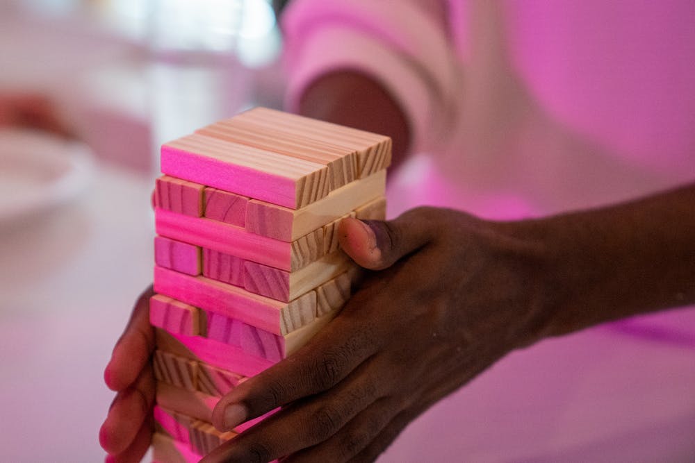 A person holding a set of jenga blocks together in their hands